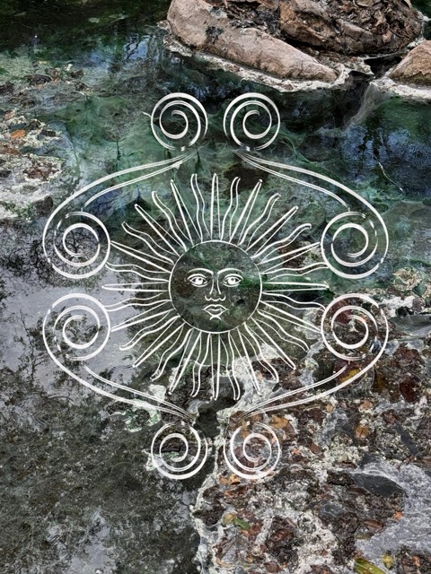 Símbolo de sol inti dibujado sobre agua y piedra